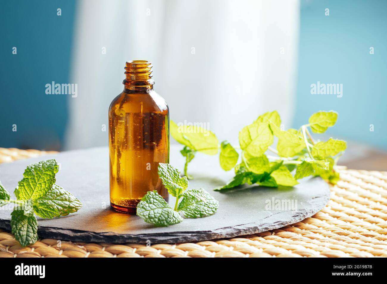 Olio essenziale di menta o menta piperita in una bottiglia di vetro utilizzata come medicina alternativa in aromaterapia o diluito in a. olio di supporto direttamente sulla pelle Foto Stock