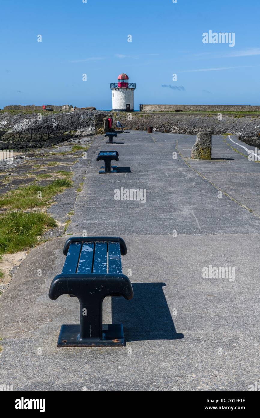 Porto muro e panchine e faro a Burry Port Carmarthenshire sulla costa meridionale del Galles Foto Stock