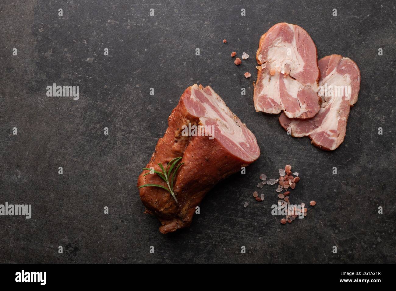 Aggiunta di gammon affumicato a fette di erbe fresche e spezie aromatiche. Prodotto naturale da azienda agricola biologica, prodotto con metodi tradizionali Foto Stock