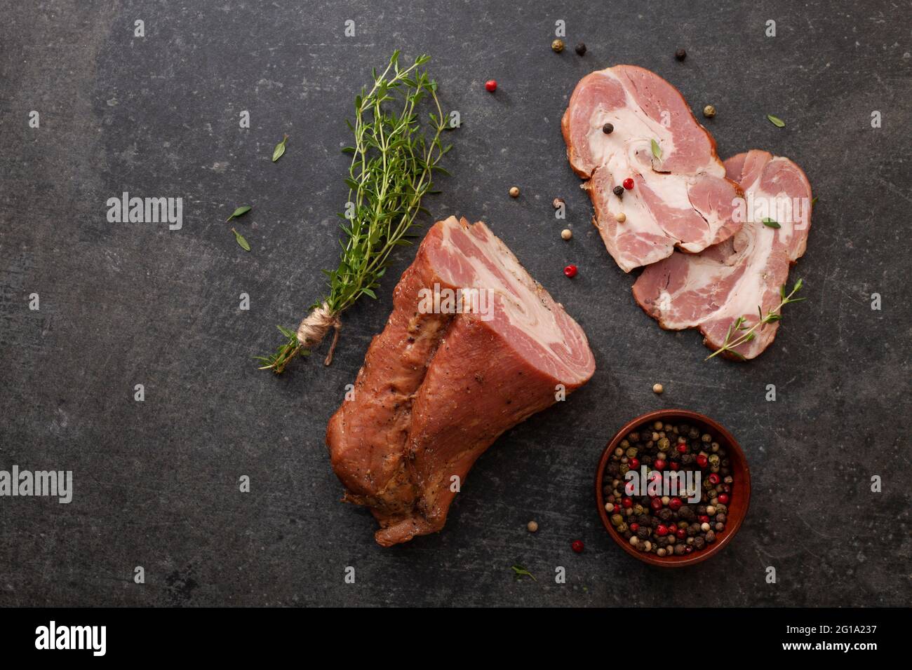 Aggiunta di gammon affumicato a fette di erbe fresche e spezie aromatiche. Prodotto naturale da azienda agricola biologica, prodotto con metodi tradizionali Foto Stock