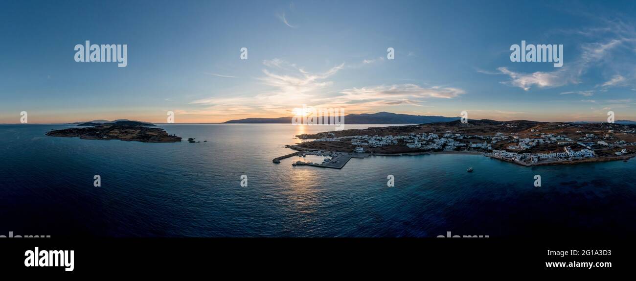 Grecia, Koufonisia piccole isole Cicladi, drone aereo vista panoramica al tramonto. Edifici bianchi tradizionali del villaggio, spiaggia sabbiosa, porto e porticciolo. Foto Stock