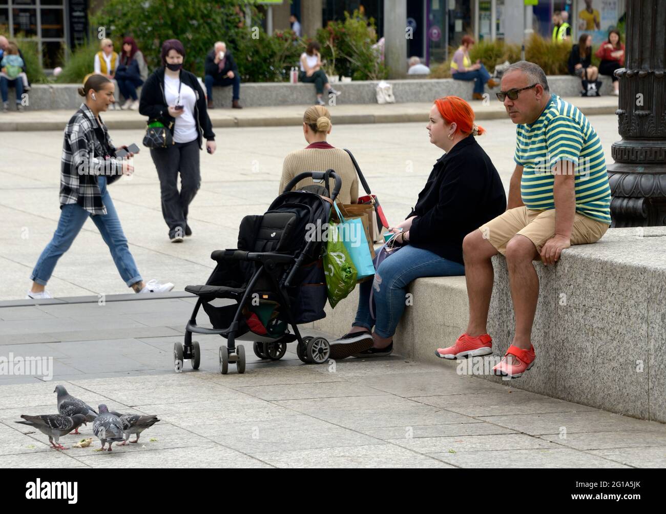 Persone che passavano tempo, sedette nel centro della città. Foto Stock