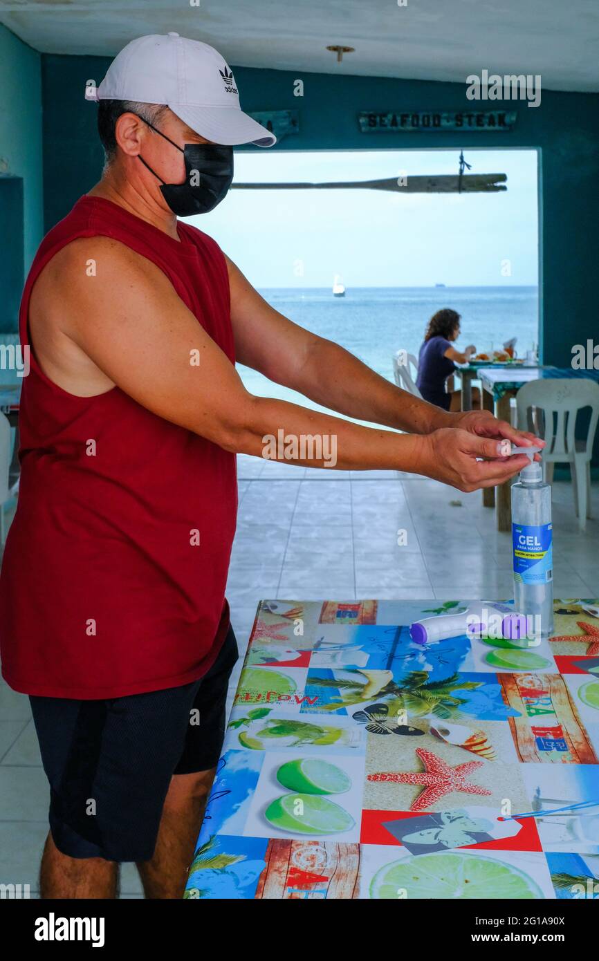 Uomo sanitizzante mani in un piccolo ristorante di pesce in Yucatan Messico durante il Coronavirus Pandemic Foto Stock