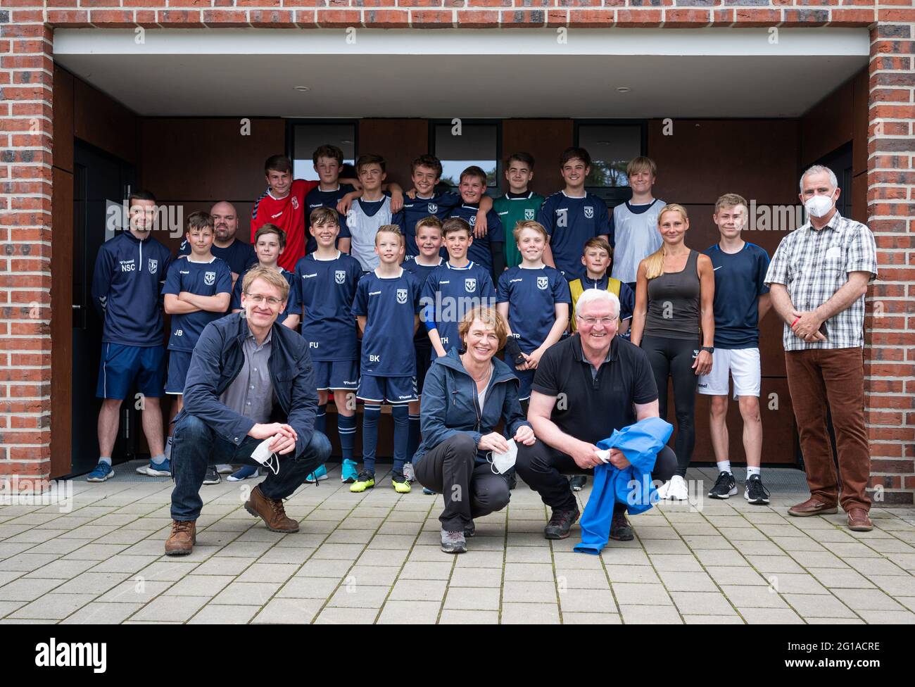 06 giugno 2021, Schleswig-Holstein, Groß Grönau: Il presidente federale Frank-Walter Steinmeier (front, r), la moglie Elke Büdenbender (front, m) e Daniel Günther (front, l, CDU), presidente del ministro Schleswig-Holstein, Insieme a una squadra di calcio giovanile di TSV Eintracht Groß Grönau, potrai scattare una foto di gruppo al confine tra Schleswig-Holstein e Meclemburgo-Pomerania occidentale. Foto: Daniel Reinhardt/dpa Foto Stock