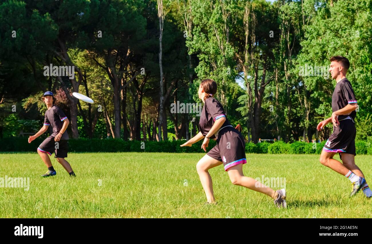 Gruppo di giovani adolescenti in squadra indossare giocare una partita di frisbee nel parco oudoors. L'uomo lancia un frisbee ad un compagno di squadra in una partita di frisbee finale. Foto Stock