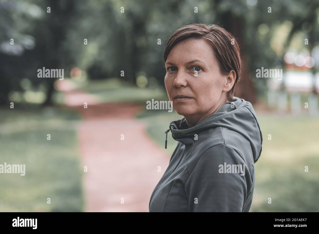 Ritratto di jogger femminile adulto in parco pronto per correre in pista, stile di vita sano e attività ricreative negli anni '40 Foto Stock