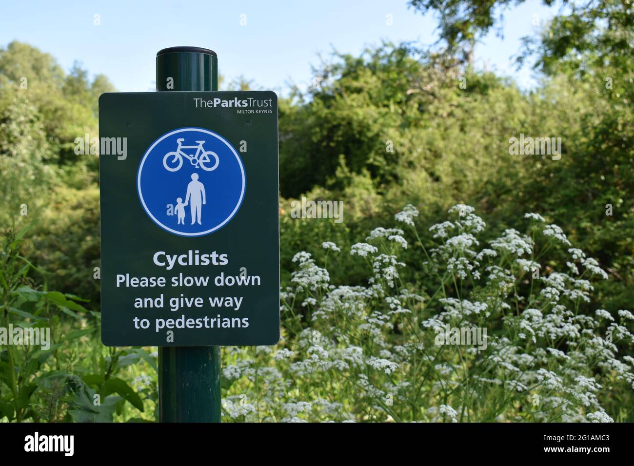 Avviso per i ciclisti: 'Dare modo ai pedoni' con copyspace. Foto Stock