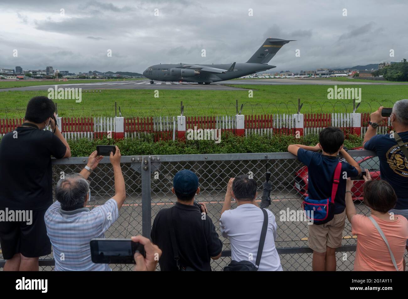 La gente scatta le foto degli aerei da trasporto della US Air Force C-17 Globemaster III sbarcati all'aeroporto Shongshan di Taipei. Gli Stati Uniti doneranno 750,000 dosi di vaccino COVID-19 a Taiwan come parte del programma del paese di condividere milioni di jab a livello globale. Tre senatori statunitensi Tammy Duckworth, Dan Sulivan e Chris Coons, hanno visitato Taiwan domenica 6 giugno, prendendo la US Air Force C-17 Globemaster III Freighter, piuttosto che un jet privato come è generalmente il caso per i visitatori senior degli Stati Uniti, Che ha dimostrato l'impegno degli Stati Uniti nei confronti di Taiwan in quanto si trova ad affrontare la sua più grande epidemia da quando la pandemia ha iniziato un Foto Stock