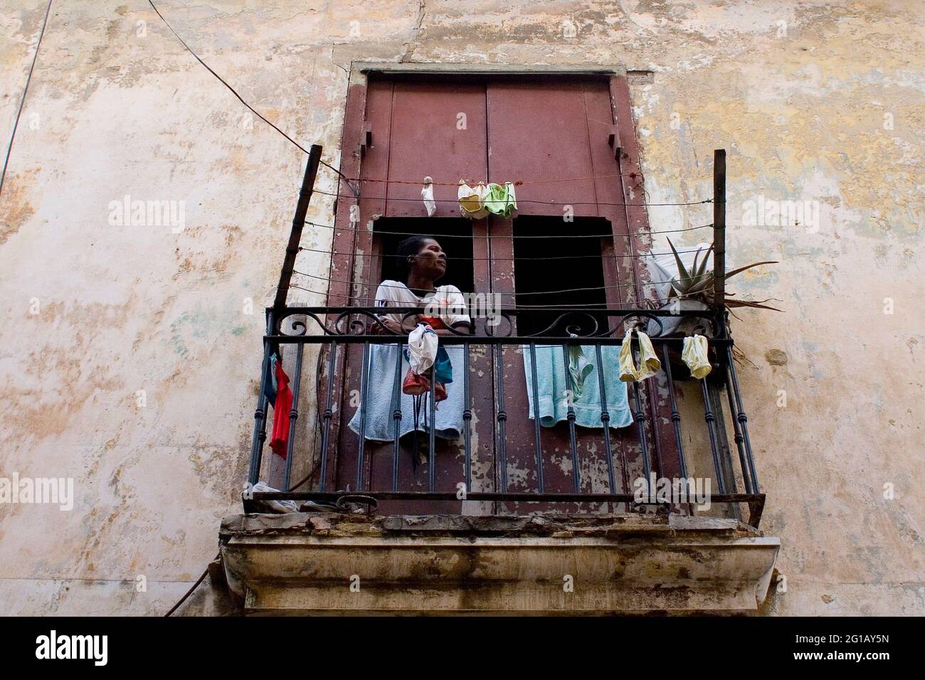 Un uomo si erge sul balcone. Havana City, 50° anniversario della rivoluzione socialista. Cinquant'anni dalla caduta del governo Batista. Così iniziò lo Stato rivoluzionario socialista, sotto le truppe di Fidel Castro, che Guevara e Camilo Cienfuegos. Nel 2009, mentre la società cubana rimane in costante adattamento e dopo che il regime è entrato in un nuovo periodo post-sovietico sociale ed economico, Cuba riflette la necessità di cambiamenti rivoluzionari odierni. L'Avana, Cuba. 2 gennaio 2009. Foto Stock