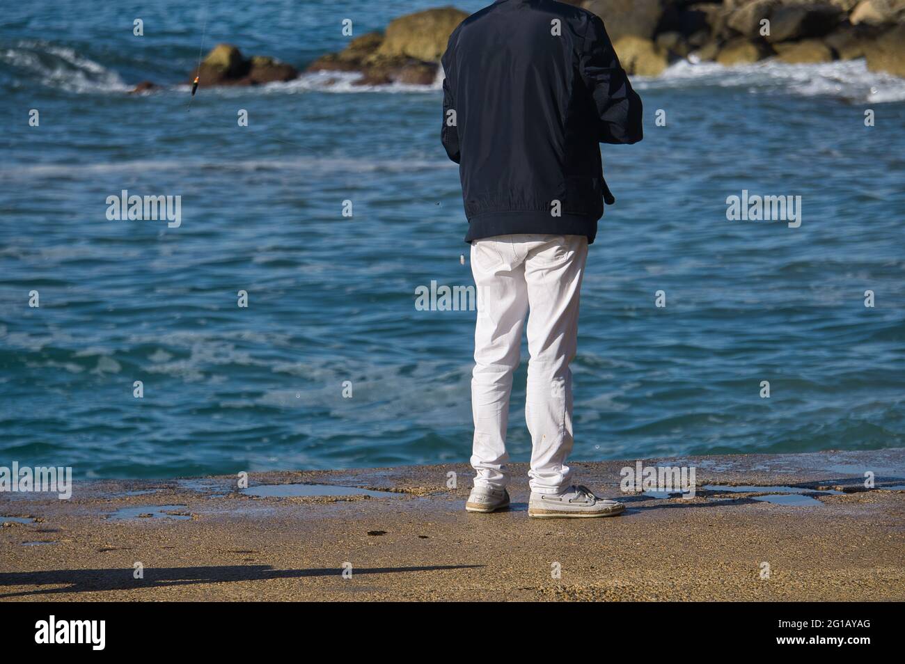 Persona pesca sulla costa della città di Alicante, nella Comunità Valenciana, Spagna. Vista Foto Stock