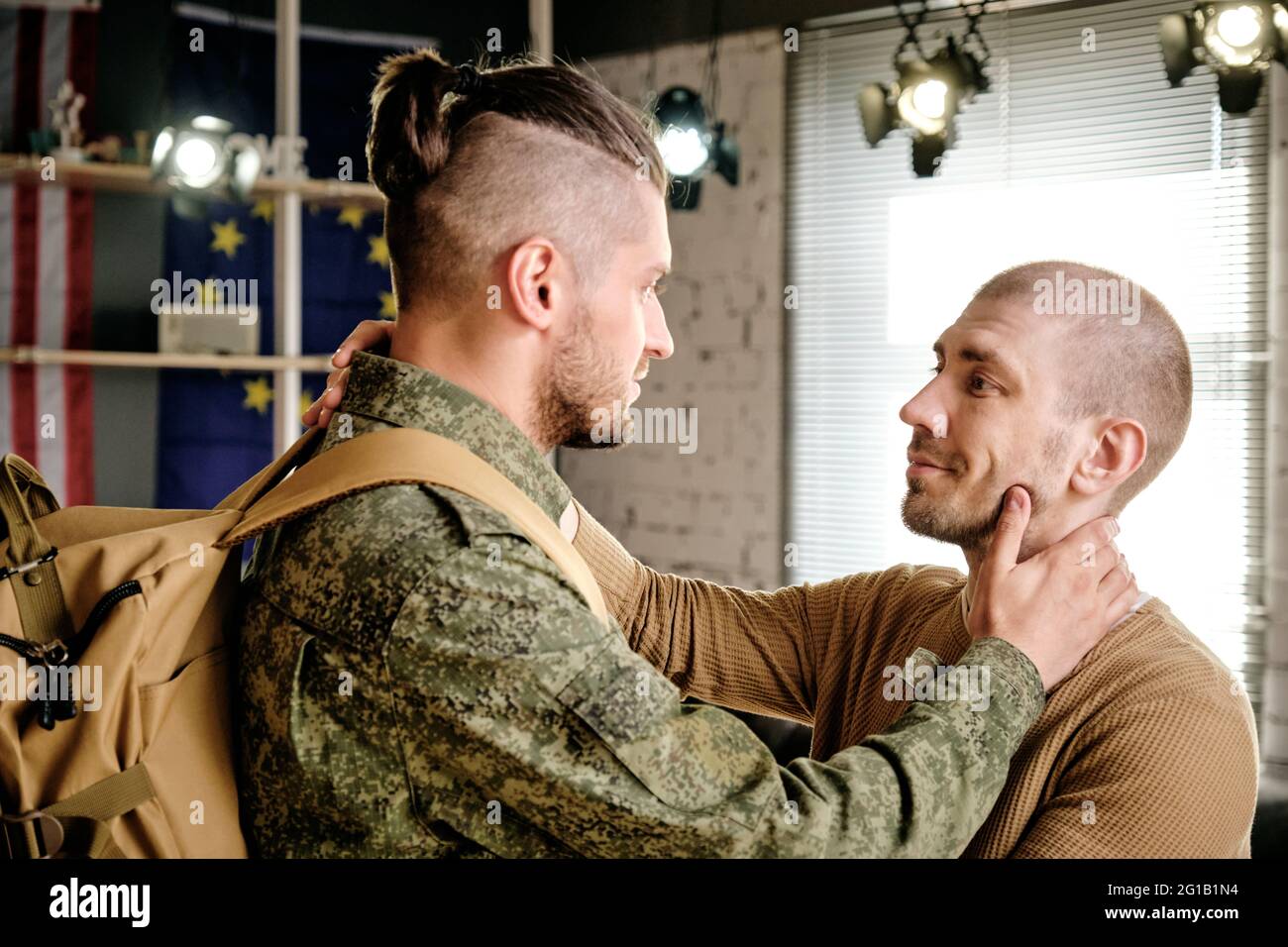 Due maschi gay che si guardano l'un l'altro di fronte alla telecamera in ambiente domestico Foto Stock