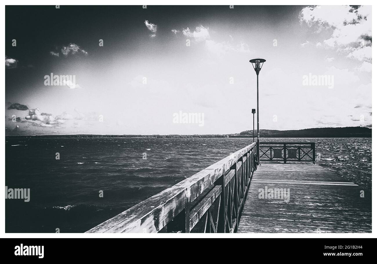 Passeggiata e molo sulla spiaggia del Lago di Tsarnowice in Polonia in una calda giornata estiva. Sulla riva di una bella baia e luogo di pesca. Foto Stock