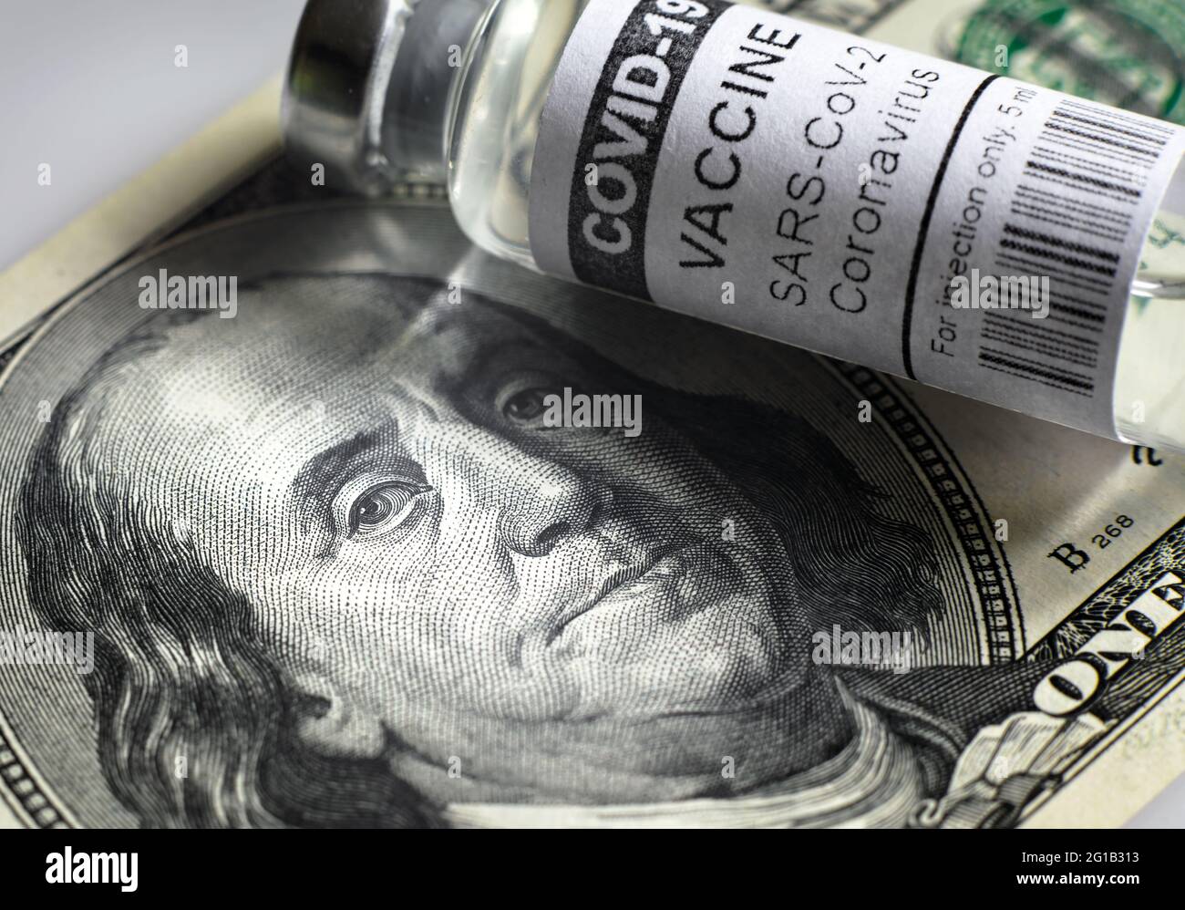 Fiala di vaccino COVID-19 e bolletta del dollaro, ritratto di Franklin sulla banconota da denaro statunitense e bottiglia di farmaco del coronavirus. Concetto di prezzo del vaccino, costo, busine Foto Stock
