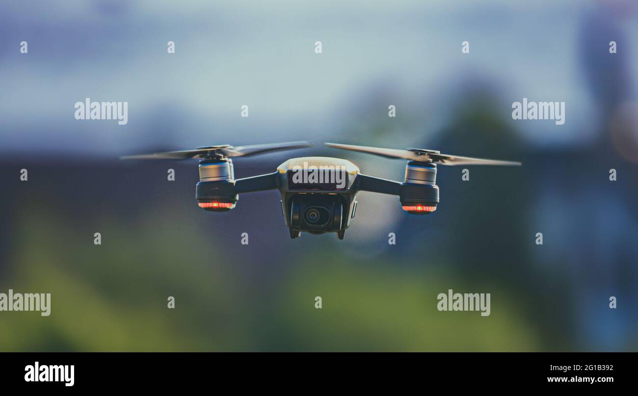 Drone in aria in posizione di sorvolo con bellissimo effetto bokeh - veicolo aereo senza equipaggio - aereo - giocattolo - quadcopter - telecomando radio. Foto Stock