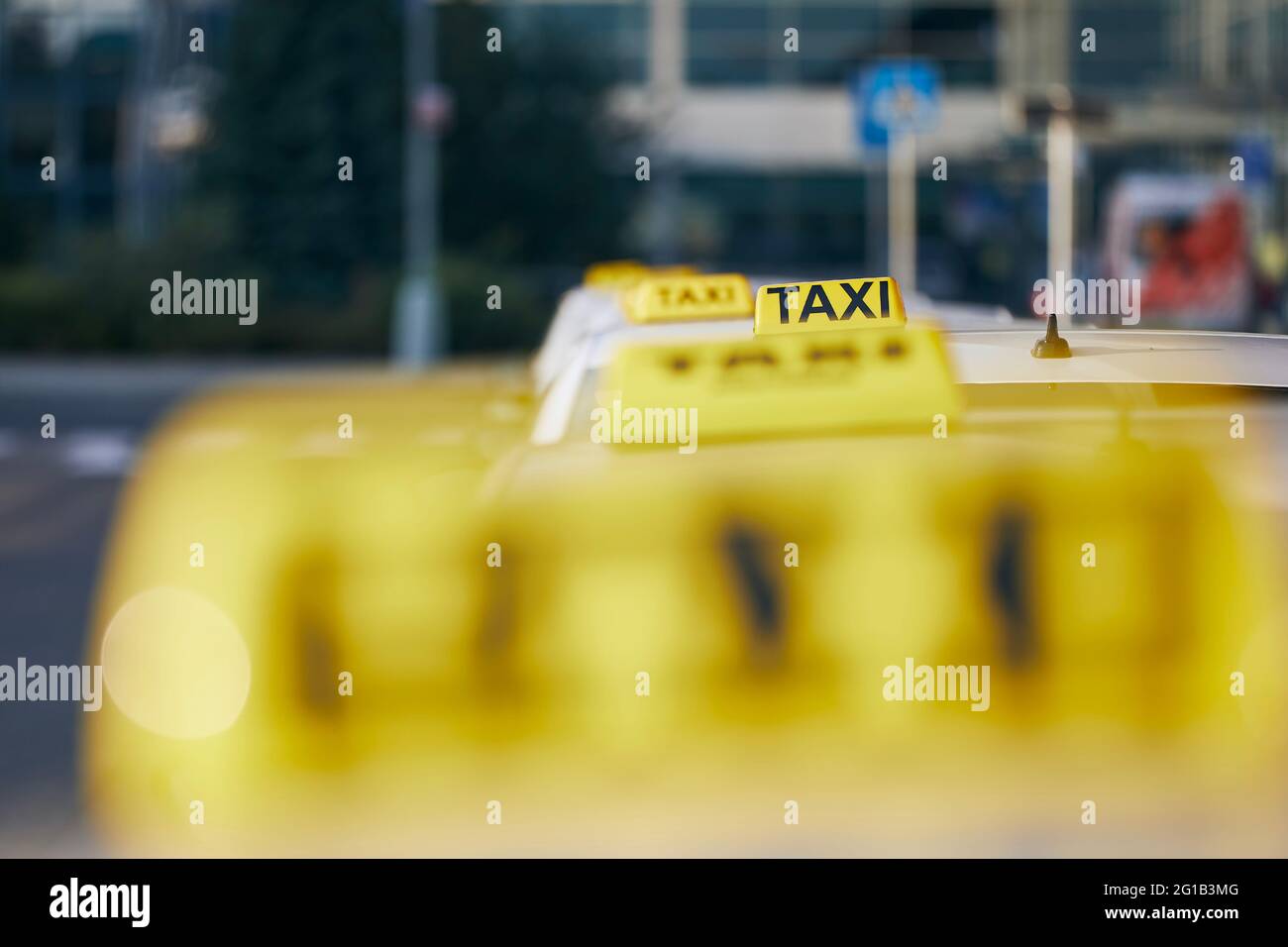 Fuoco selettivo sul segnale del taxi sul tetto. Auto in attesa di passeggeri in strada. Foto Stock