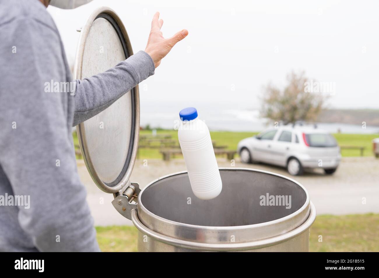 Uomo che getta contenitori di plastica al punto di riciclaggio della plastica. Responsabilità sociale. Concetto di riciclaggio. Spazio di copia. Foto Stock
