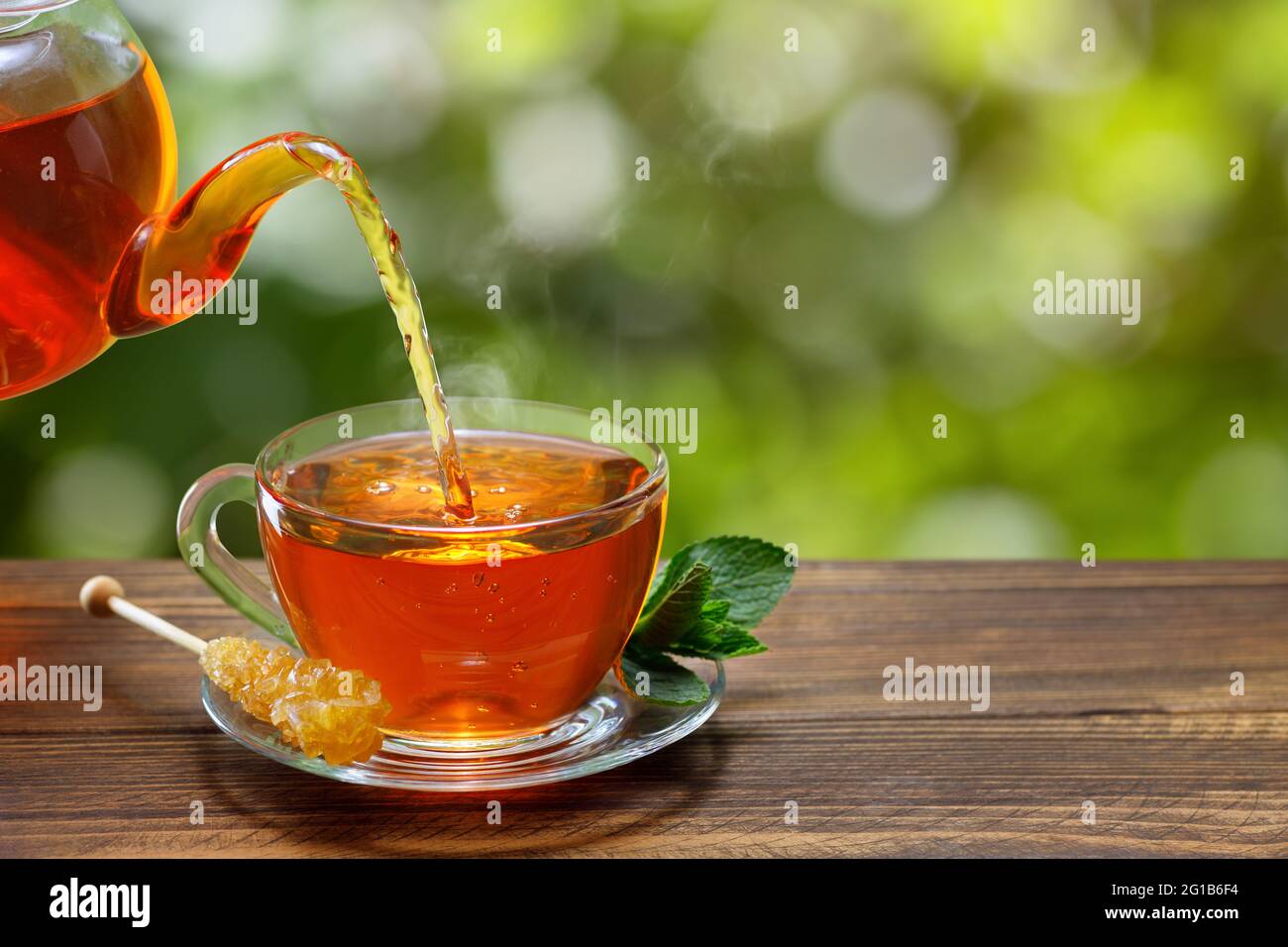 tè con la menta che si versa dalla teiera in tazza Foto Stock