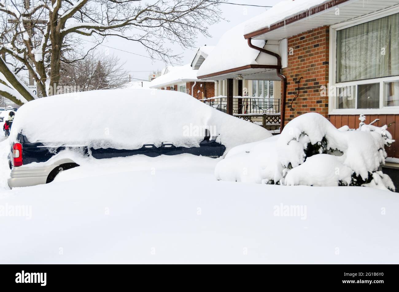 Auto parcheggiata in una casa completamente coperto di neve dopo la superstorm o il vortice polare che ha colpito Toronto durante l'inverno del 2014. Foto Stock