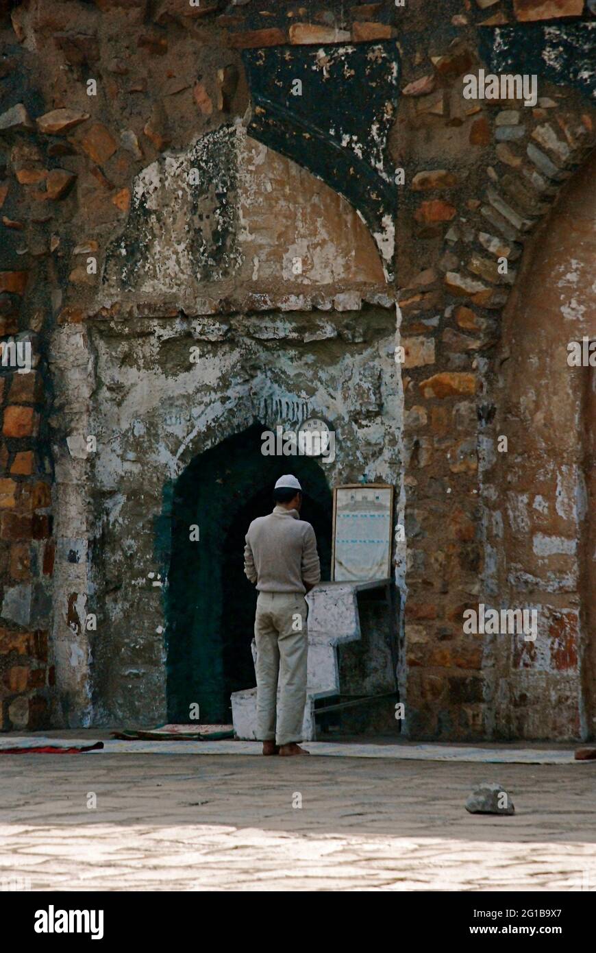 Un musulmano prega in un'antica moschea che si trova tra le rovine della città vecchia di Feroz Shah Kotla a Nuova Delhi, India. 24 marzo 2006. Foto Stock