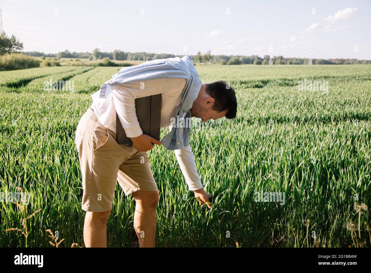 Coltivatore giovane con cartella sotto il suo braccio 40 anni di controllo del suo raccolto di foraggio, piccolo concetto di bussiness Foto Stock