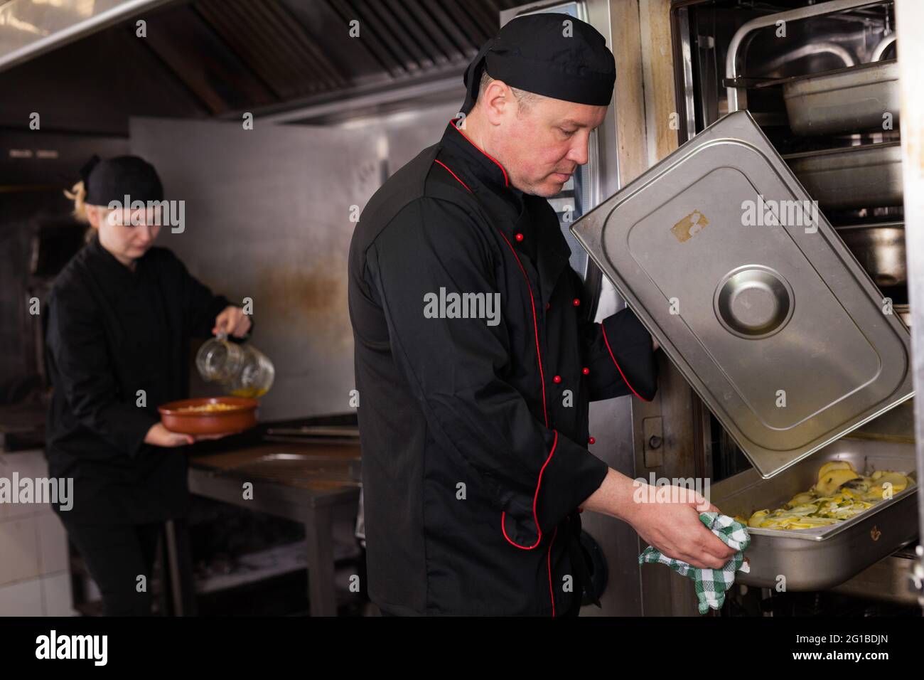 Chef preparandosi piatto fuori dal forno Foto Stock