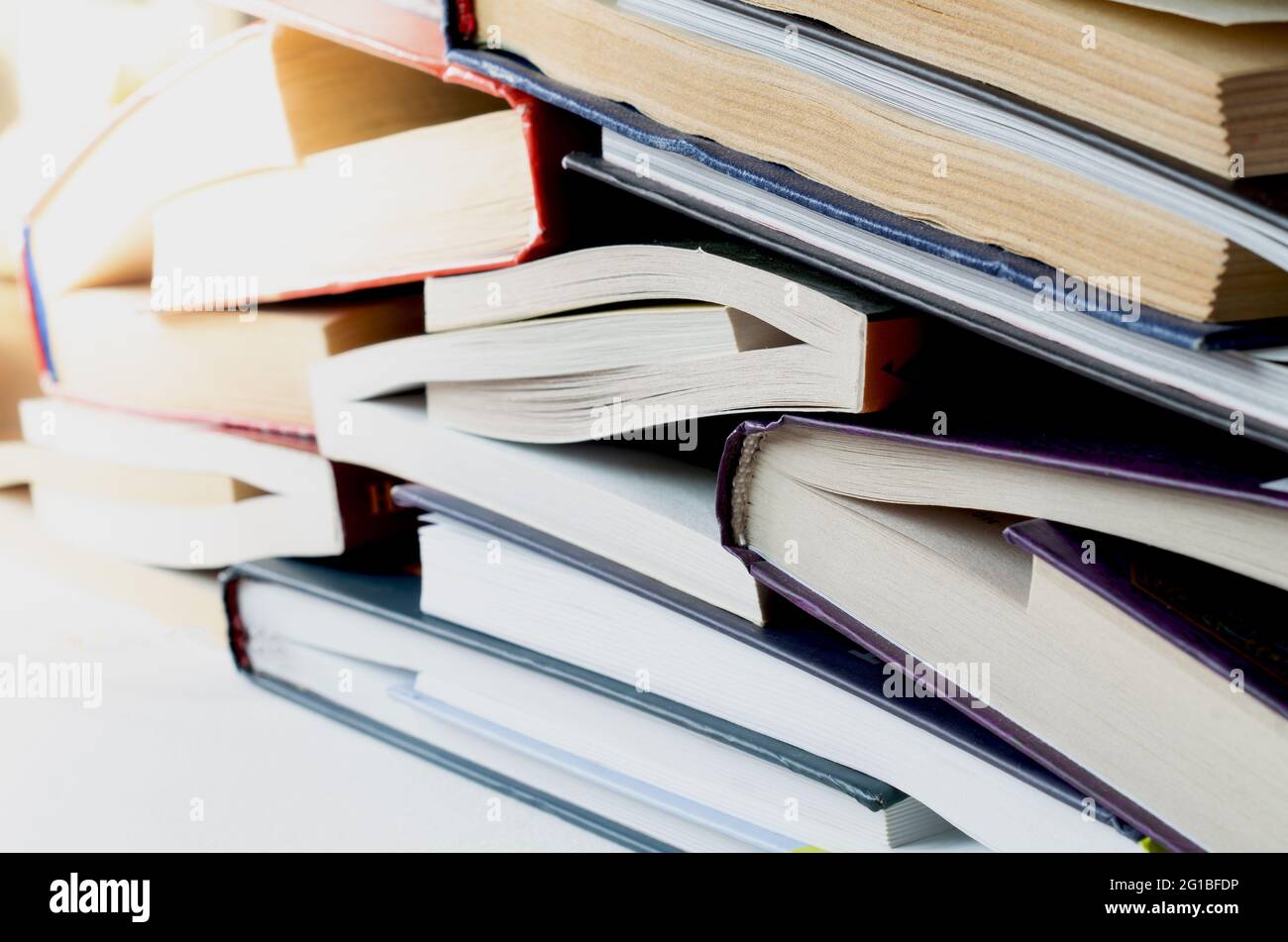 Pila di libri di copertina rigida su sfondo bianco Foto Stock