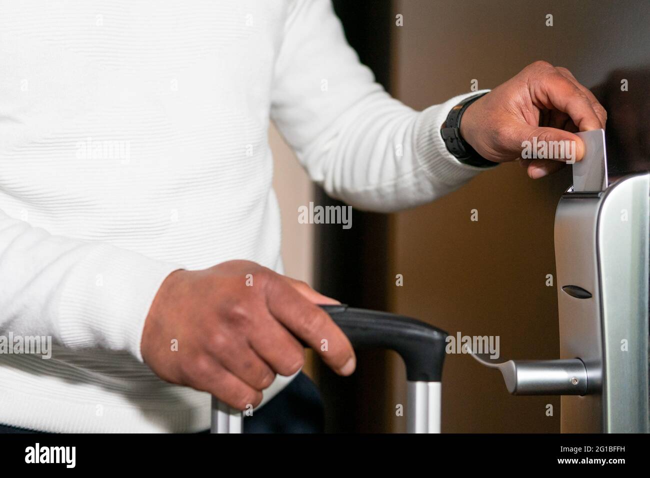 Ritagliare un maschio anonimo in abiti informali che sfiorano la carta di plastica mentre si apre la moderna porta dell'hotel Foto Stock
