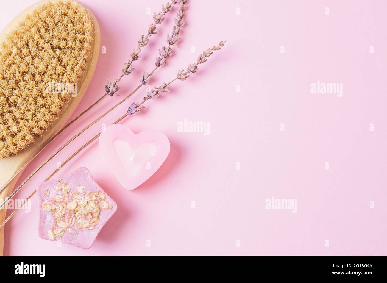 Prodotti per la cura del corpo su sfondo rosa. Sapone fatto a mano, candela, spazzola di legno per il corpo asciutto massage.Skin prodotti banner. Foto Stock