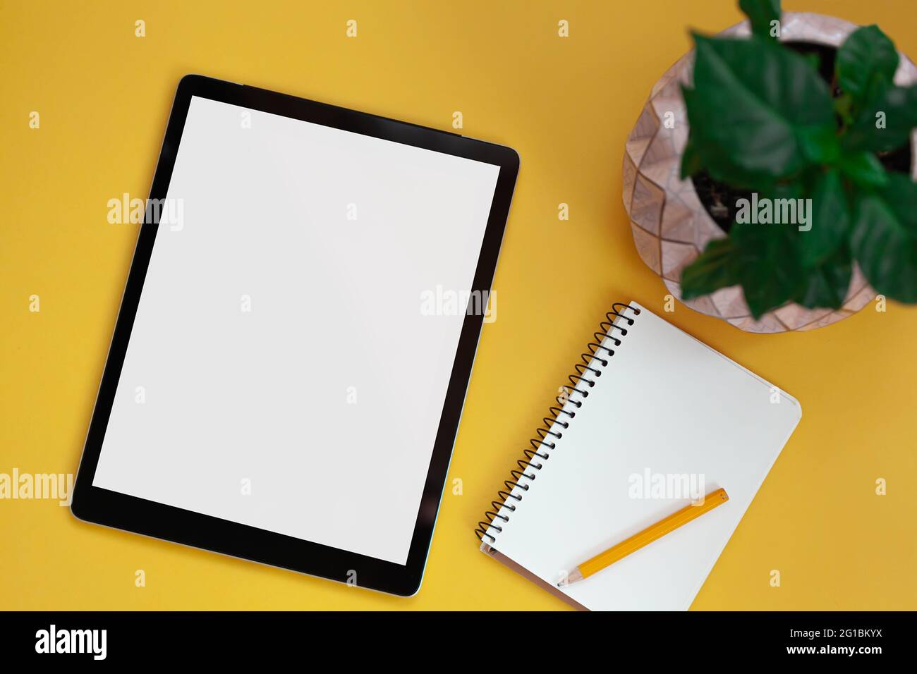 Mockup dello schermo del tablet e blocco note isolato su sfondo giallo, vista dall'alto Foto Stock
