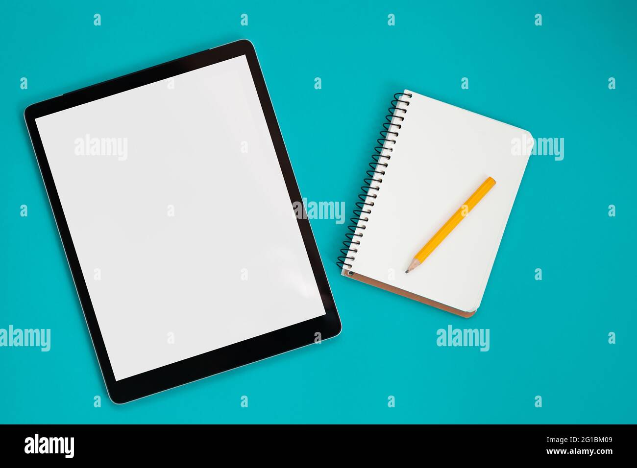 Mockup dello schermo del tablet e blocco note isolato su sfondo blu, vista dall'alto Foto Stock