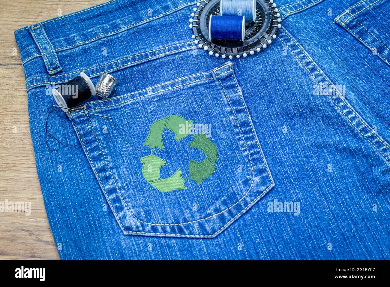 Riciclare l'icona dei vestiti su jeans, concetto di moda sostenibile, riparazione, riciclaggio, riutilizzo di vestiti e tessuti per ridurre gli sprechi Foto Stock