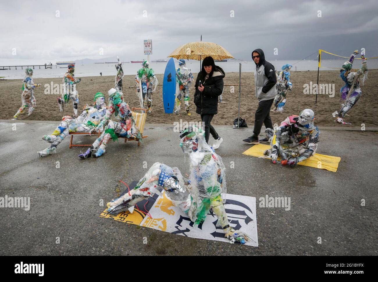 Vancouver, Canada. 6 Giugno 2021. La gente guarda le figure fatte con le materie plastiche rimosse dalle coste a Kitsilano Beach a Vancouver, British Columbia, Canada, il 6 giugno 2021. Creato dall'artista multidisciplinare Caitlin Doherty e realizzato con materie plastiche rimosse dalle coste canadesi, un insieme di figure denominate beachgoer in plastica incarnano il contributo collettivo delle persone all'inquinamento plastico, portano il tema dell'inquinamento delle coste in prima linea. Credit: Liang Sen/Xinhua/Alamy Live News Foto Stock