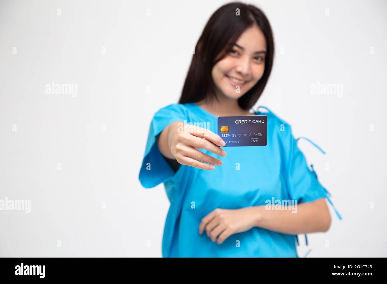 Giovane asiatico bella donna paziente mostrando personale assicurazione infortuni carta di credito isolato su sfondo bianco, PA e concetto di servizi di reclamo per la salute Foto Stock