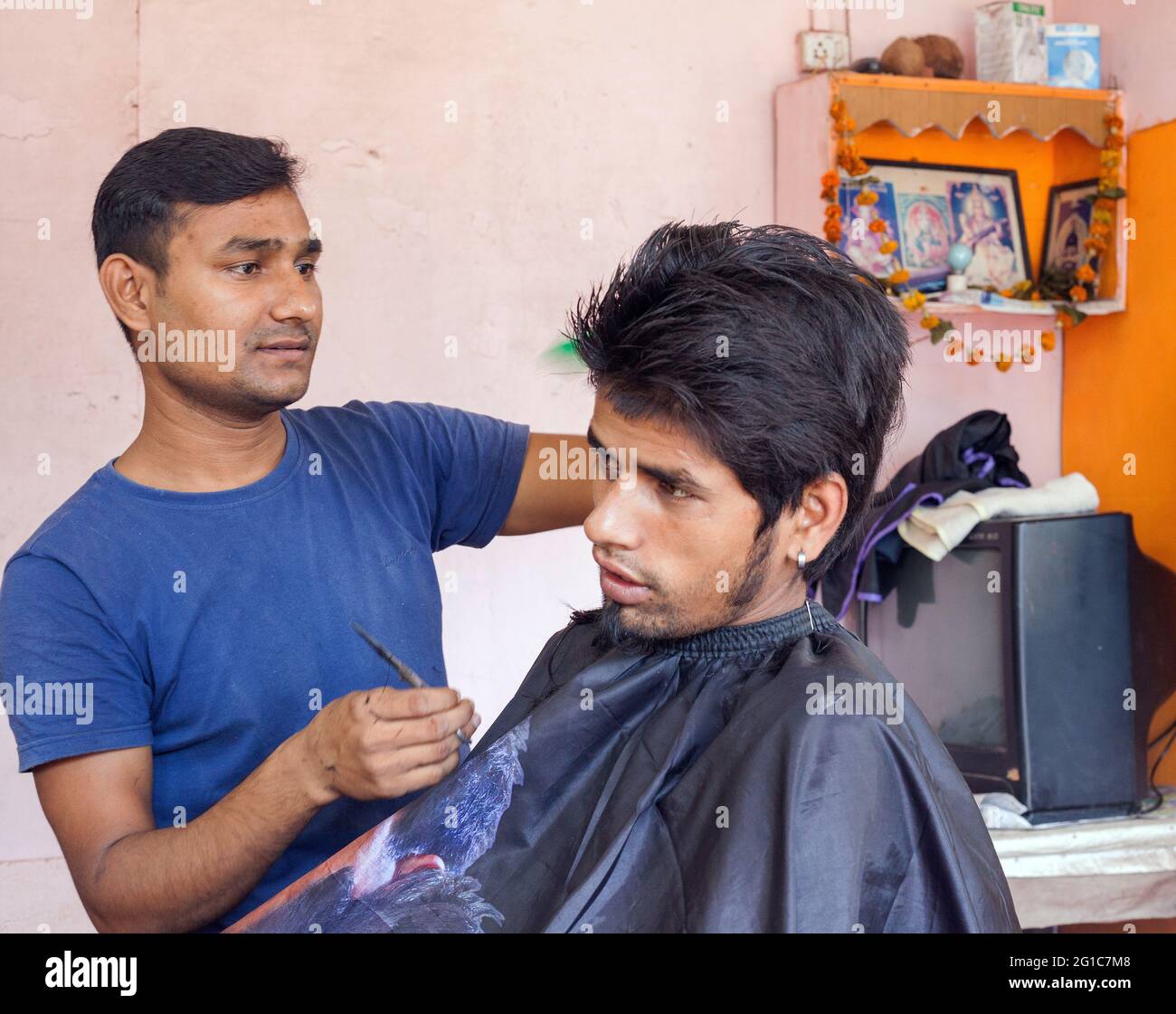 Indiano maschio con bouffant acconciatura con i suoi capelli tagliati in salone, Agonda, Goa, India Foto Stock