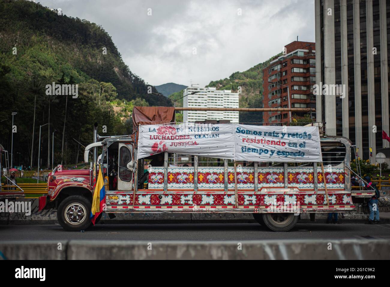 Bogotà, Colombia. 06 giugno 2021. Una 'Chiva' delle comunità indigene di Misak con una bandiera colombiana e un segno che recita 'il sangue dei nostri combattenti chiedono giustizia' e 'noi siamo le radici e i beccucci nella resistenza nel tempo e nello spazio' mentre le persone e la comunità indigena di Misak si riuniscono per aspettare l'arrivo di La Commissione interamericana per i diritti umani (CIDH) tra brutalità e disordini della polizia durante le proteste anti-governative che hanno raggiunto almeno 70 morti nell'ultimo mese di manifestazioni, a Bogotà, Colombia, il 6 giugno 2021. Credit: Long Visual Press/Alamy Live News Foto Stock