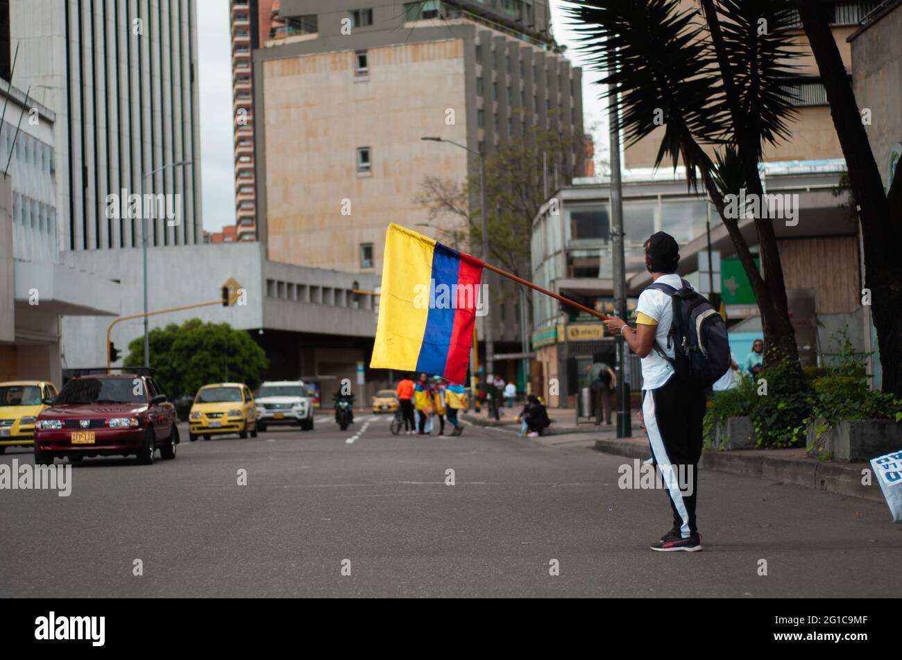 Bogotà, Colombia. 06 giugno 2021. Un uomo fa ondate una bandiera nazionale colombiana mentre la gente e la comunità indigena Misak si riuniscono per attendere l'arrivo della Commissione interamericana per i diritti umani (CIDH) tra la brutalità e i disordini della polizia durante le proteste anti-governative che hanno raggiunto almeno 70 morti nell'ultimo mese di manifestazioni, a Bogotà, Colombia il 6 giugno 2021. Credit: Long Visual Press/Alamy Live News Foto Stock