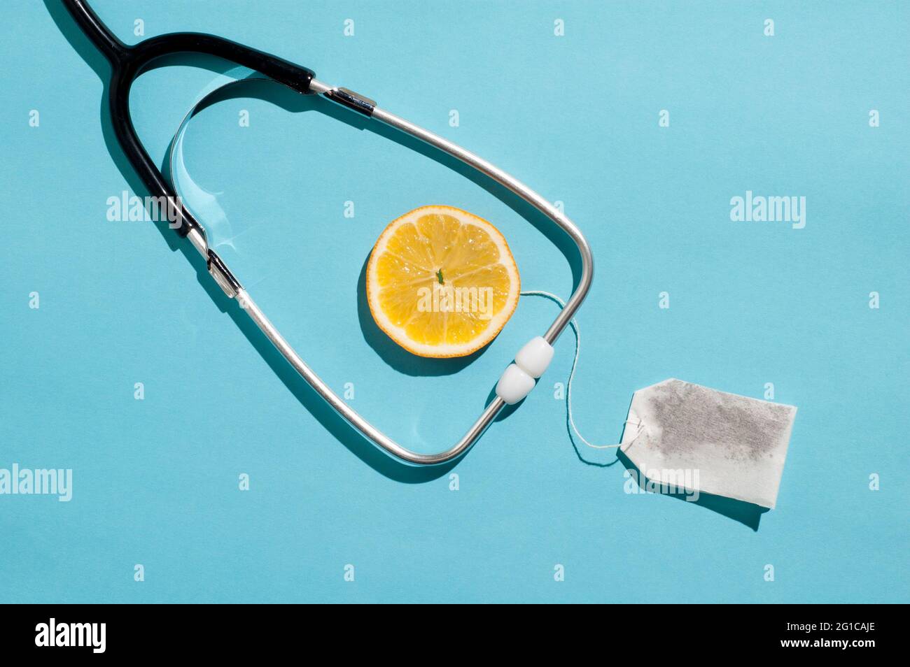 Layout di concetto sanitario minimo con uno stetoscopio tradizionale e ingredienti tè al limone Foto Stock