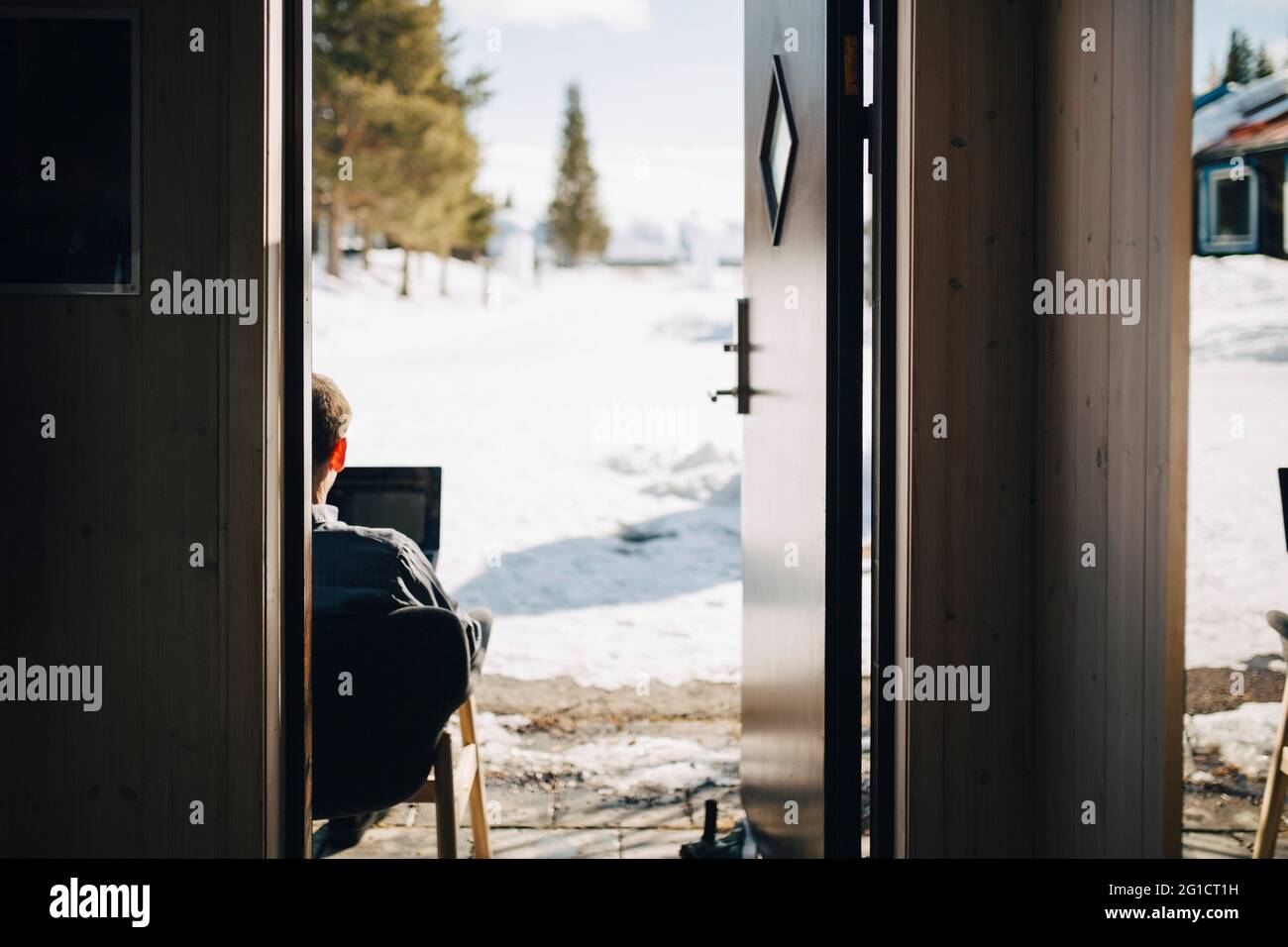 Uomo d'affari che lavora visto attraverso la porta Foto Stock