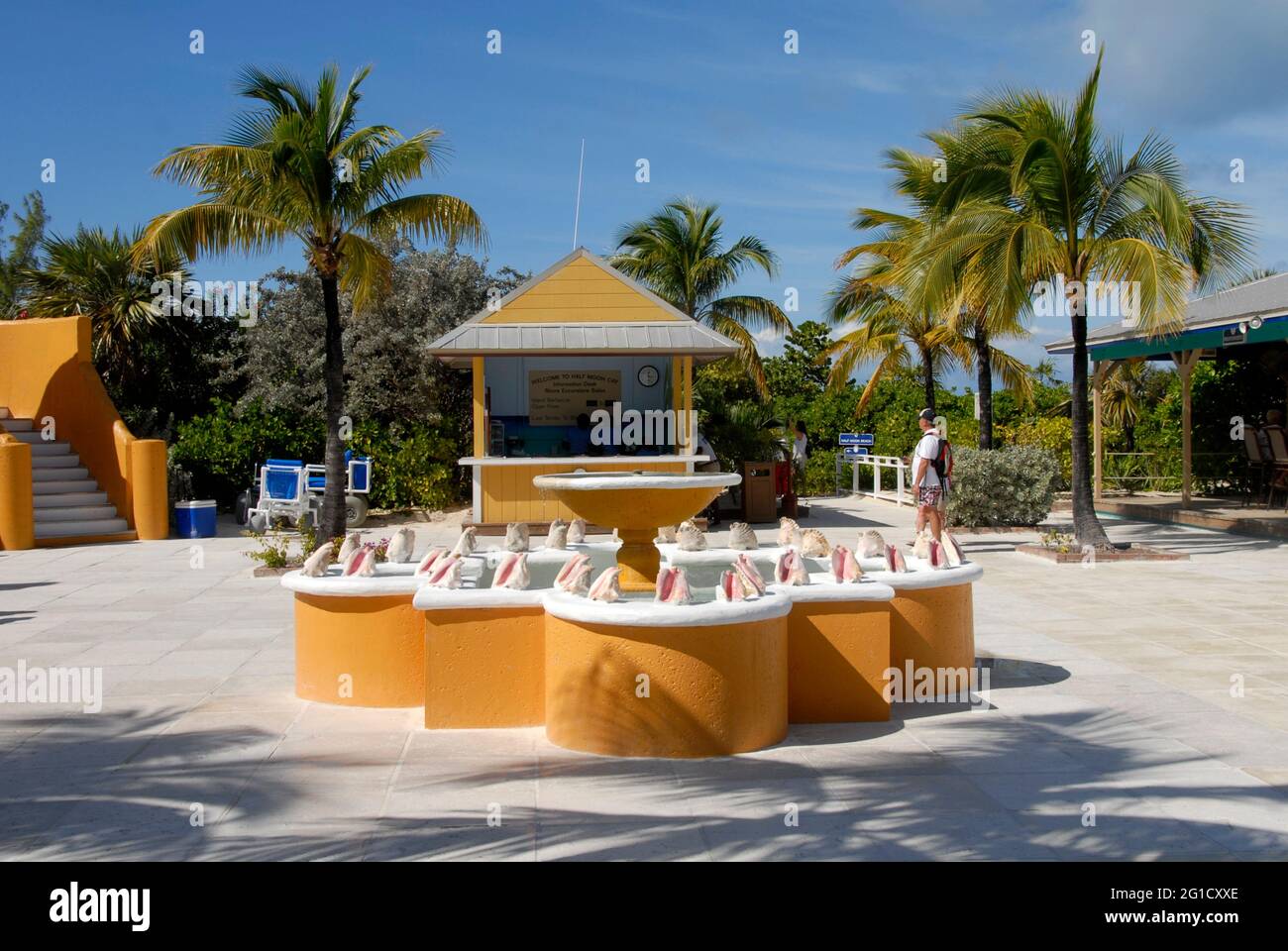 Banco informazioni presso Half Moon Cay, Bahamas con piscina e fontana di fronte con conchiglie montate sul bordo superiore per la decorazione Foto Stock