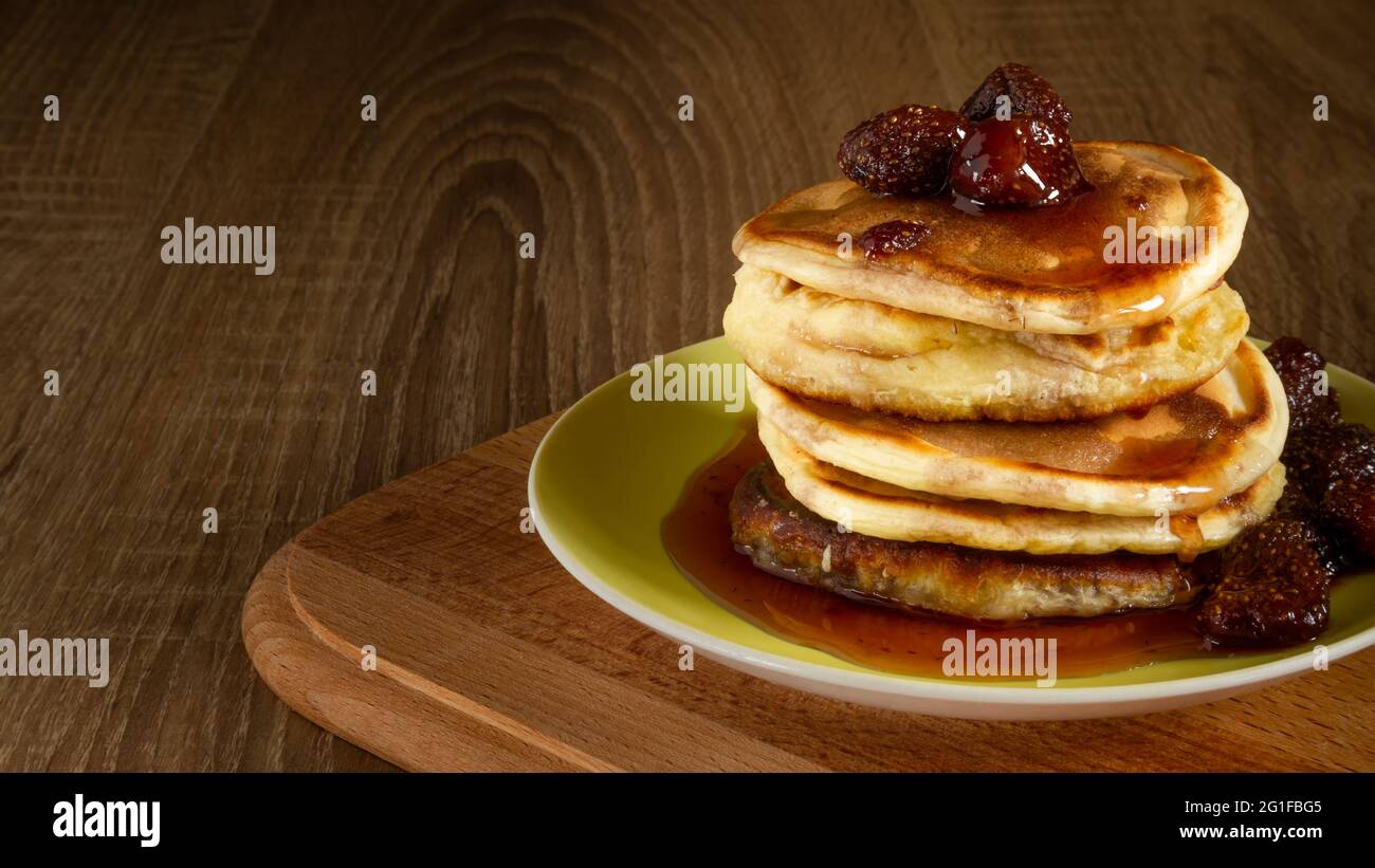 Diversi pancake con marmellata di fragole e frutti di bosco su tavola di legno Foto Stock