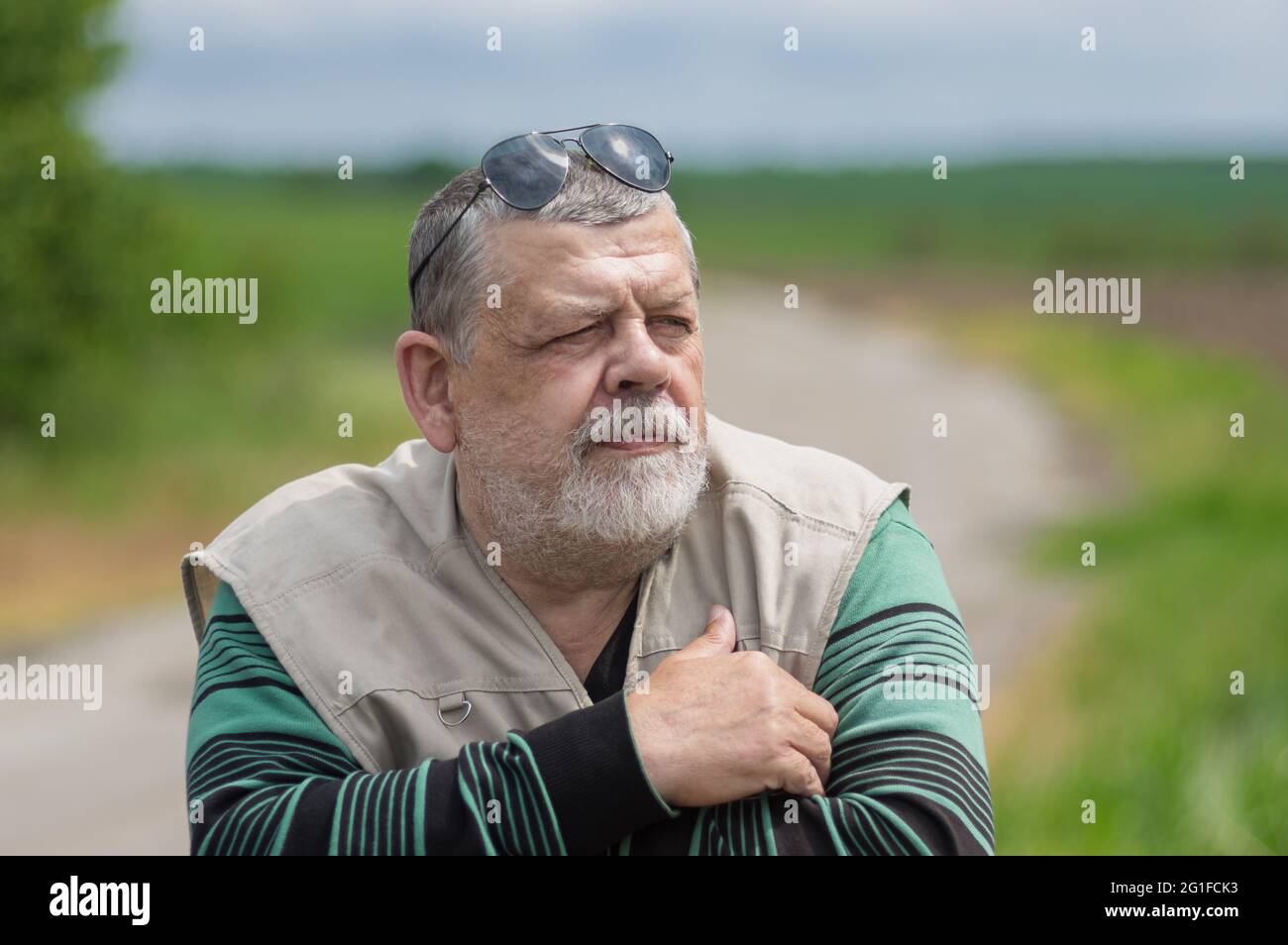 Bel ritratto all'aperto di un uomo caucasico con bearded che indossa occhiali da sole neri sulla parte superiore della testa e guarda in avanti Foto Stock