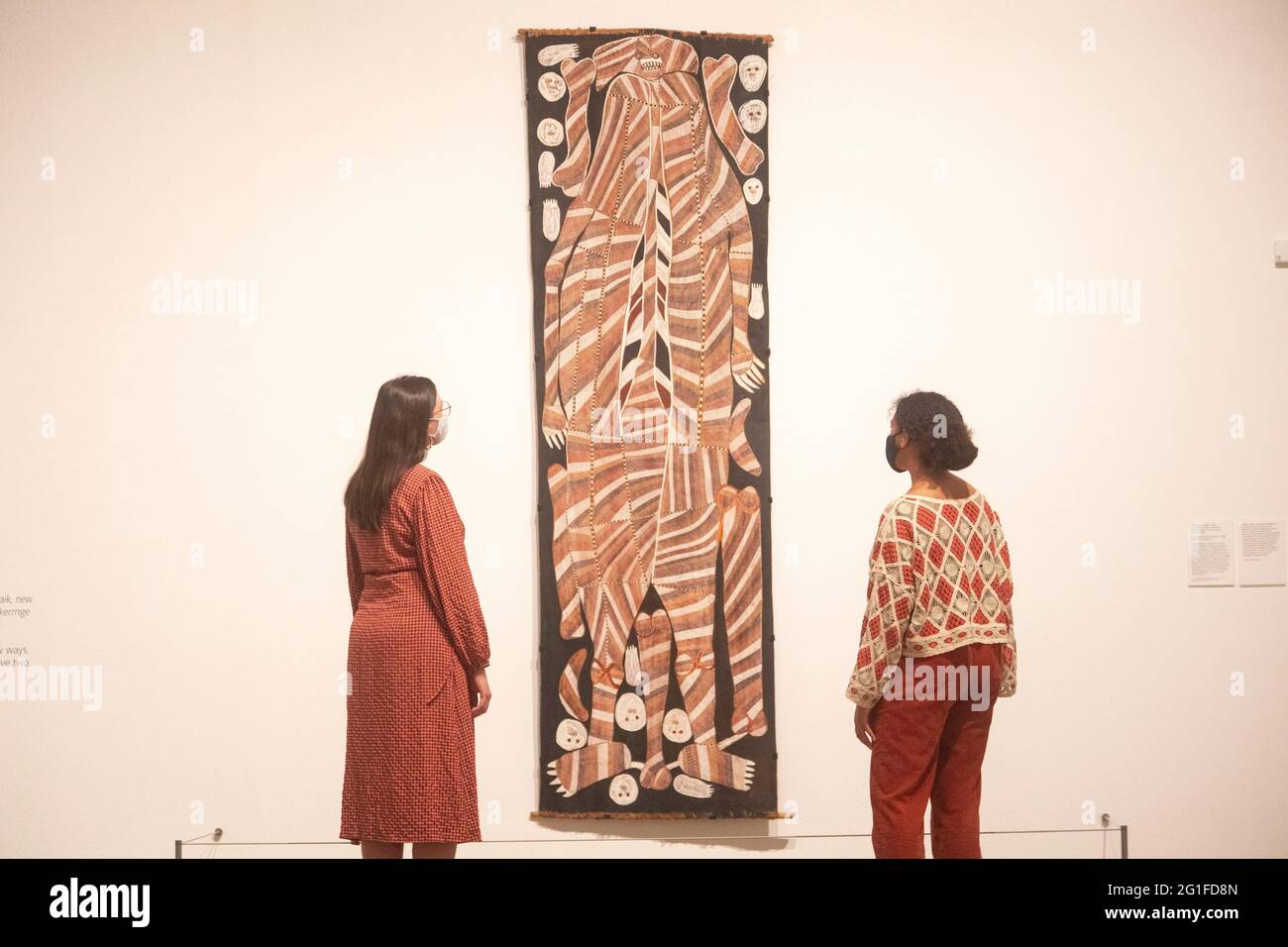 I membri del personale guardano a Buluwana, l'antenato femminile 1989 di John Mawurndjul, un dipinto sulla corteccia che è un materiale utilizzato dalla gente di Kuninkju per scopi pratici e cerimoniali, in mostra nell'A Year in Art: Australia 1992 mostra libera a Tate Modern, Londra. Data immagine: Lunedì 7 giugno 2021. Foto Stock
