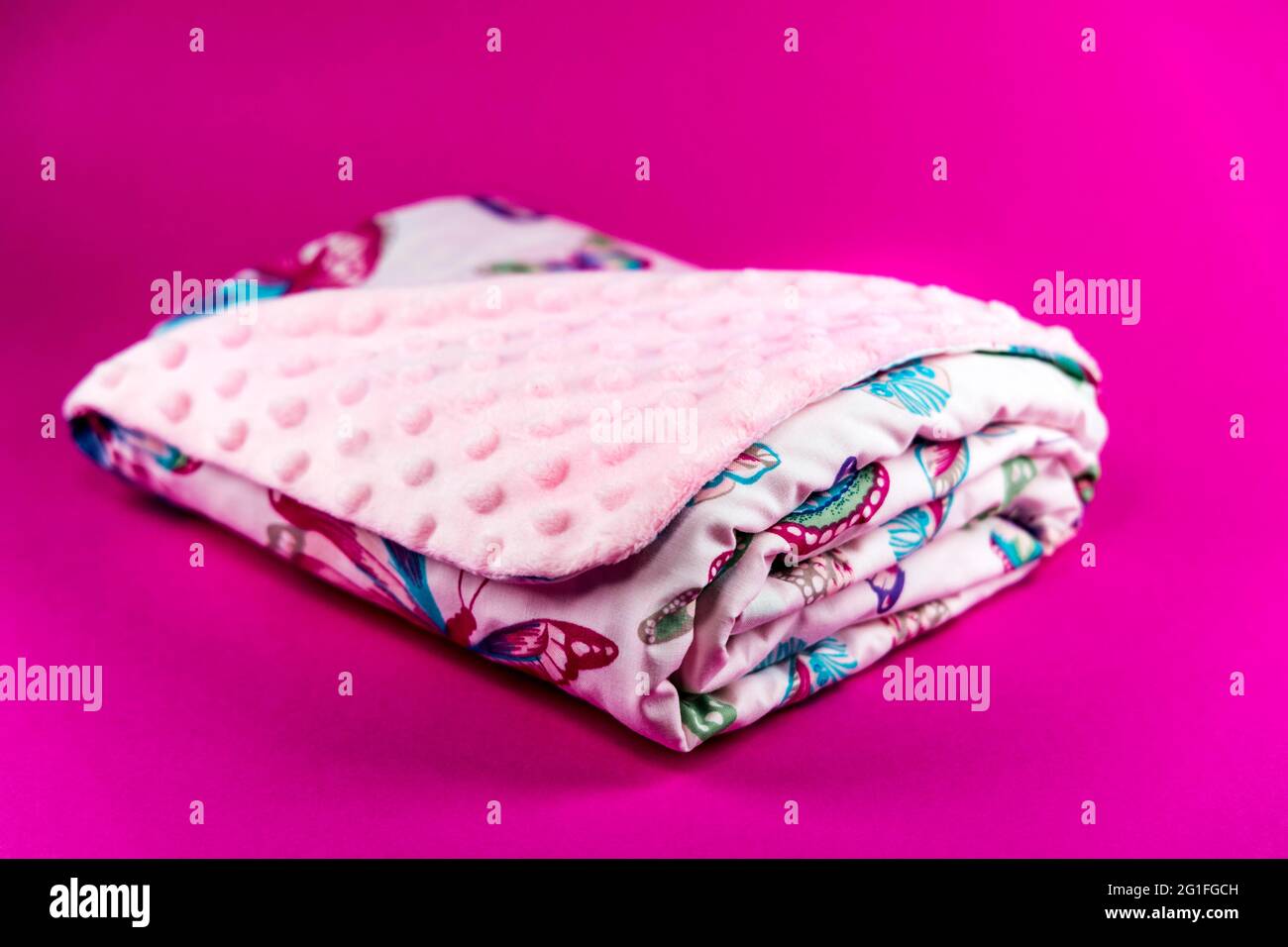 Dolce e carina coperta rosa con farfalla modello isolato su sfondo rosa Foto Stock