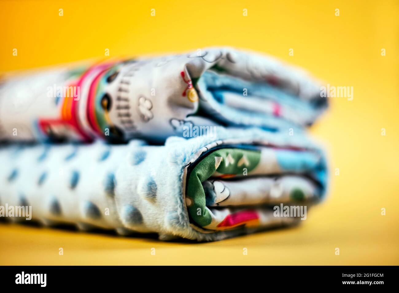 Coperta dolce e accogliente con treno modello isolato sfondo giallo Foto Stock