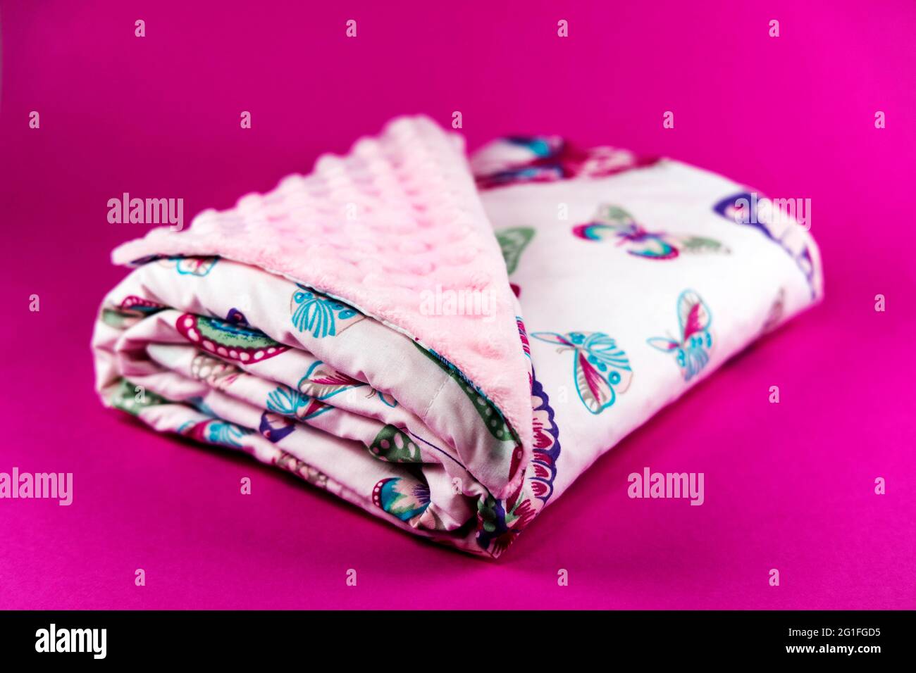 Dolce e carina coperta rosa con farfalla modello isolato su sfondo rosa Foto Stock