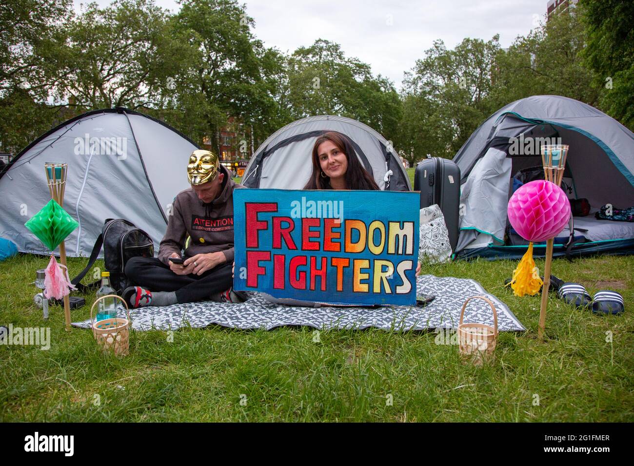 'Freedom Fighters' - una giovane donna che tiene il suo segno ad un campo di protesta di libertà su Shepherd's Bush Green, Londra, Regno Unito. Giugno 2021 Foto Stock