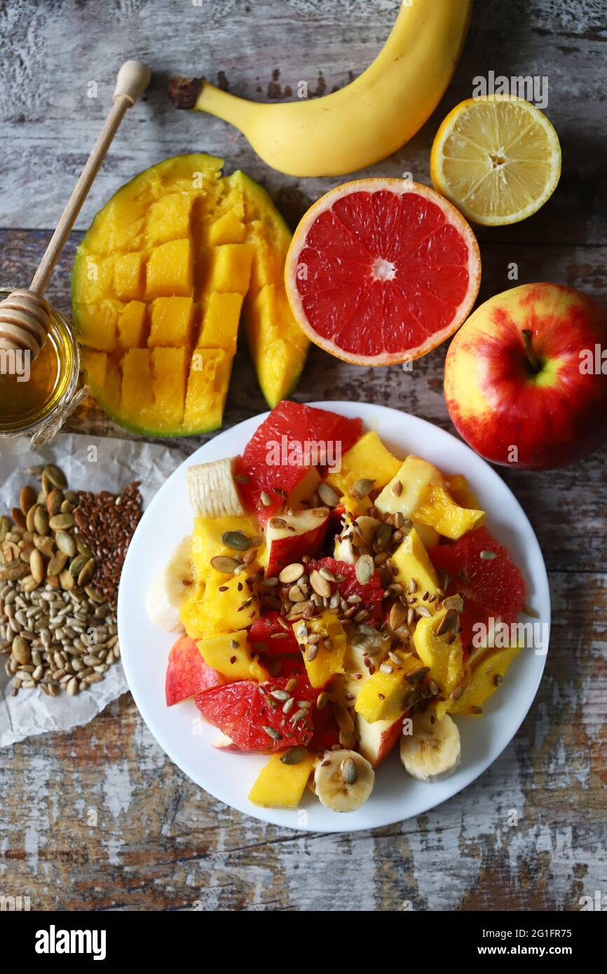 Insalata di frutta nutriente e super fresca con semi. Insalata con mango, banana e pompelmo. Cibo vitaminico. Cibo sano. Foto Stock