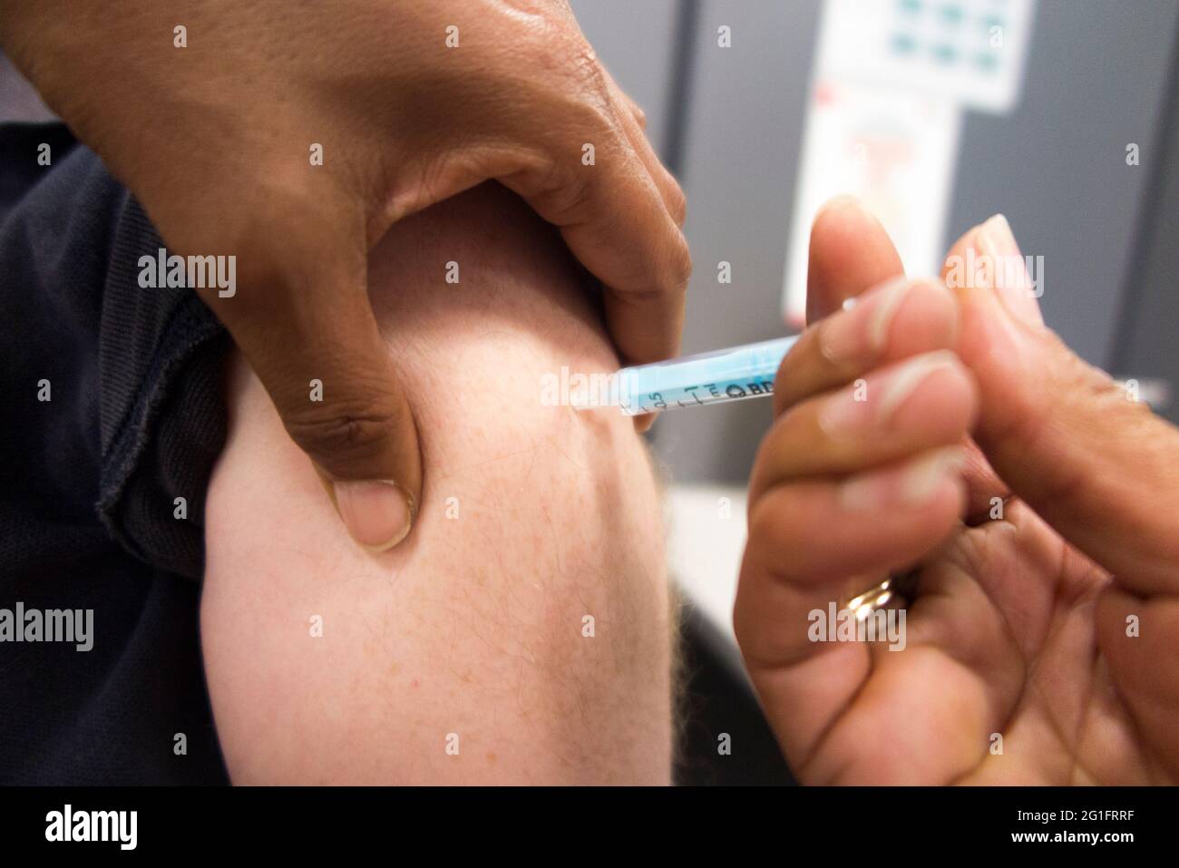 AstraZeneca / Astra Zeneca covid 19 vaccino del coronavirus che viene iniettato con una siringa ipodermica nel braccio di un uomo negli anni 50. Londra, Regno Unito. Questa è la seconda dose, quindi la persona sarà completamente vaccinata. (123) Foto Stock