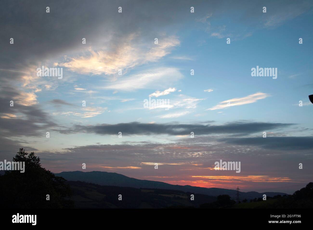 Tramonto estivo e le montagne lungo la vale di Conwy Snowdonia in una serata estiva vicino al villaggio di Eglwysbach Conwy Galles del Nord Foto Stock