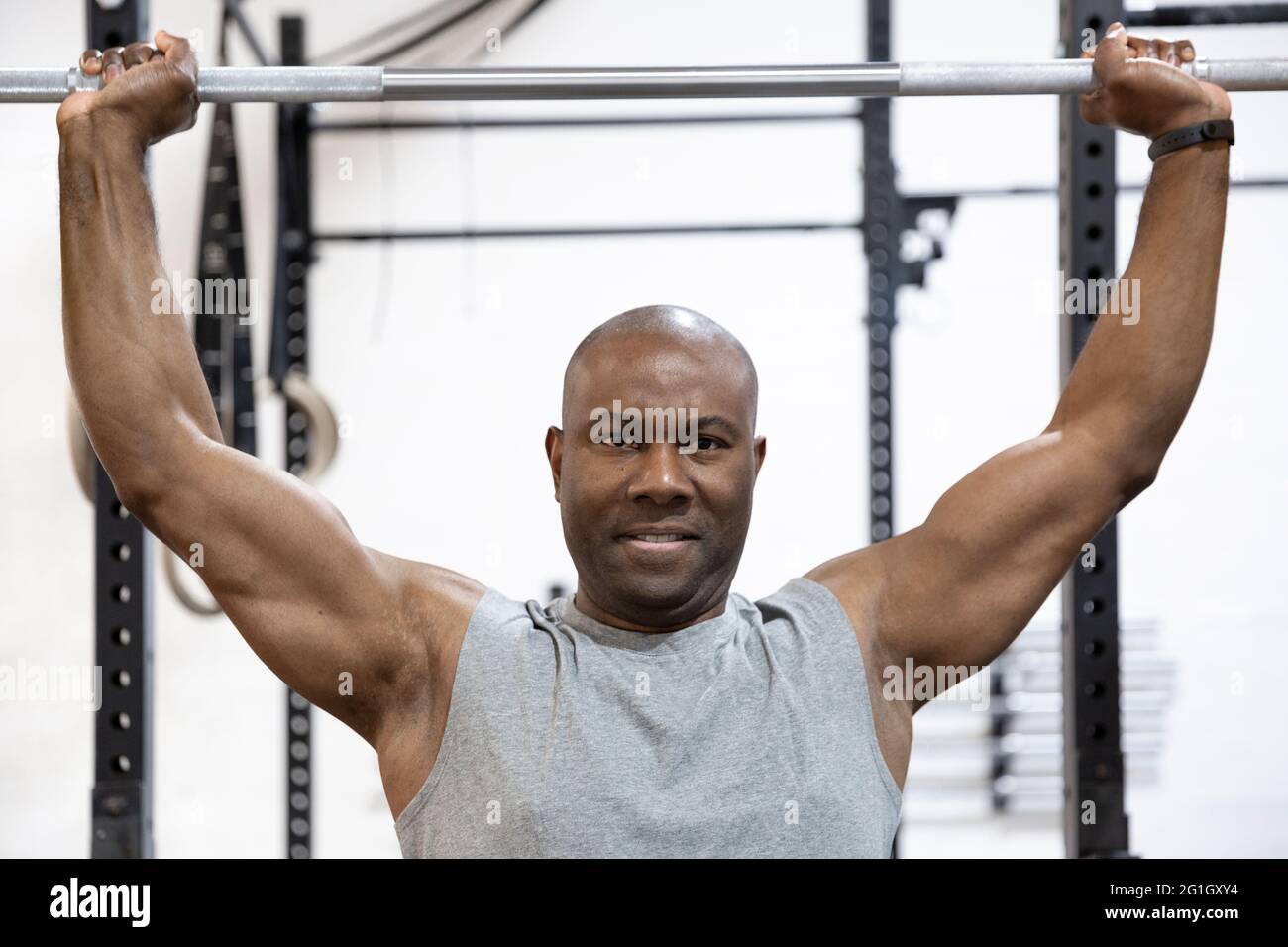 Ritratto di bodybuilder afroamericano che fa sforzo fisico in palestra. Allenamento duro. Foto Stock
